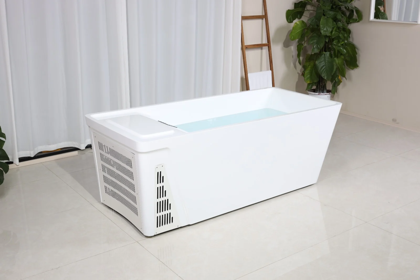 Cada de răcire Chill Tub 801, de formă dreptunghiulară, albă, cu un interior umplut cu apă, amplasată pe un podea din gresie lucioasă, înconjurată de un perete cu draperii albe și o plantă verde în apropiere.