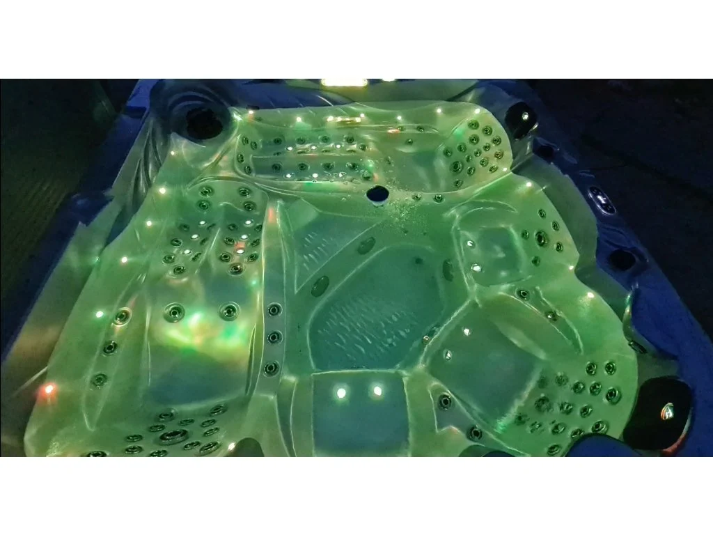 Cadă cu hidromasaj New Maximus, iluminată cu lumini verzi, cu un design modern și un interior spațios pentru 4-5 persoane, având 136 de jeturi de masaj și un finisaj din acril antibacterian.