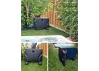 Pompă de căldură ZEALUX pentru jacuzzi, de culoare neagră, amplasată într-un mediu de grădină, cu vegetație verde în jur și un perete de lemn în fundal.